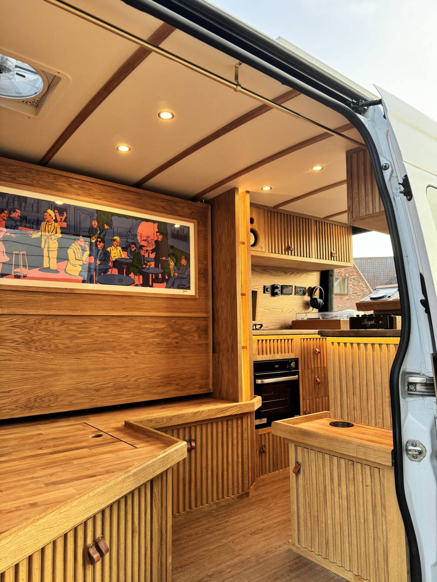 Timber campervan conversion with fitted cabinets and kitchen
