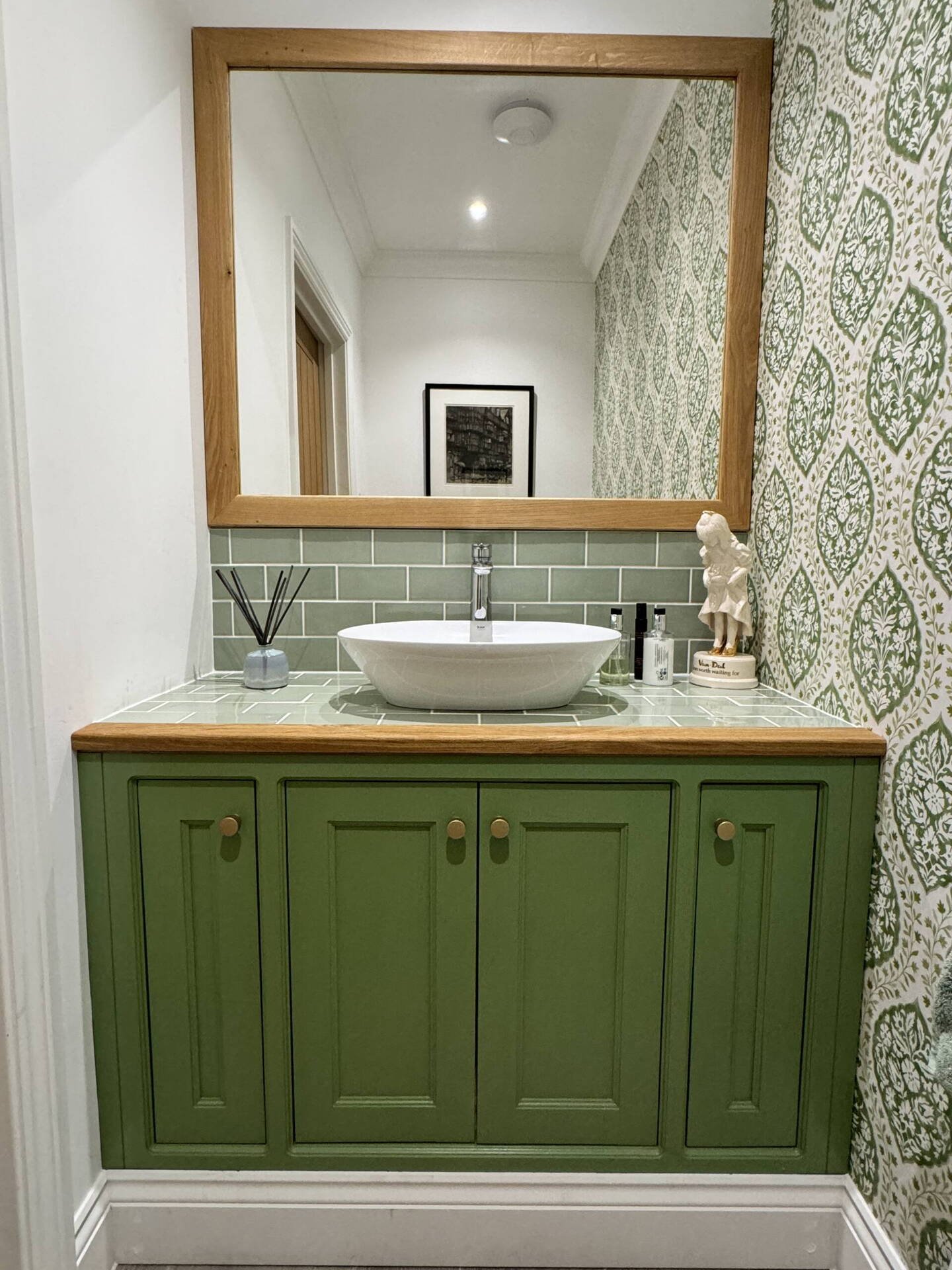 Green painted vanity unit with oak top and countertop basin