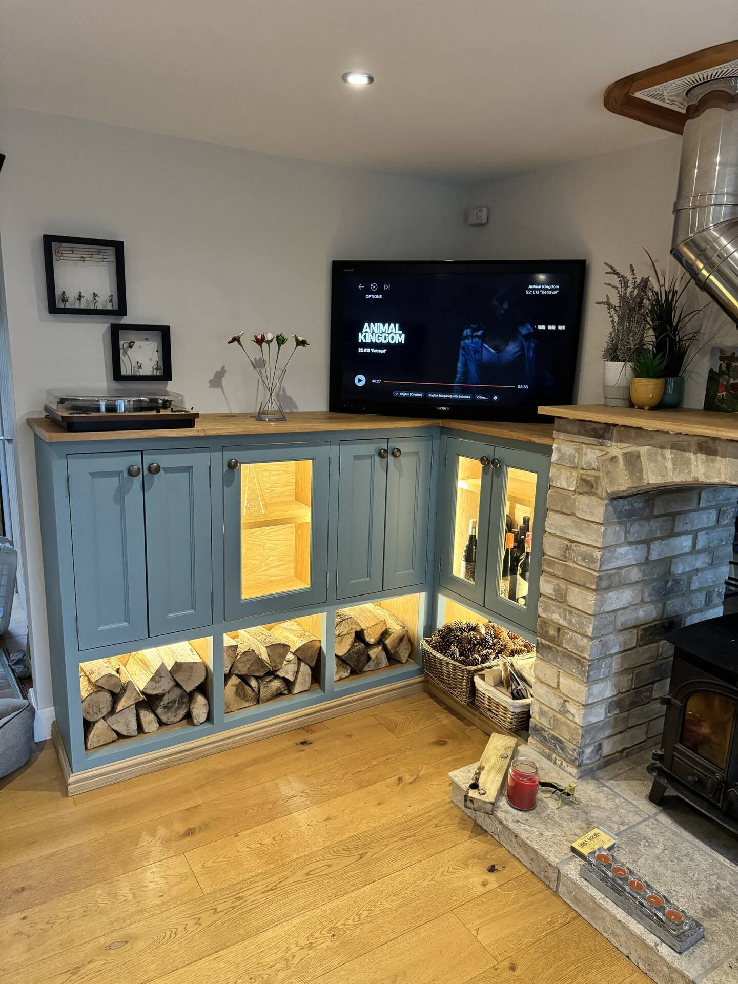 Painted fitted corner units with log stores, oak top and lit display cabinet